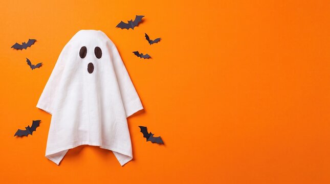 A cute white ghost costume surrounded by small black bats on a vibrant orange background for halloween celebration themes