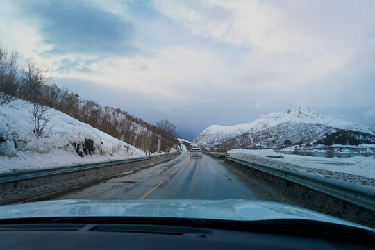 POV winter road trip driving through scenic snow covered mountains landscape in Lofoten Norway