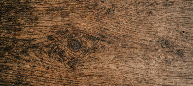 A close-up view of a textured wooden surface that showcases the natural grain patterns and rich brown hues, suitable for backgrounds and design purposes.