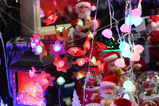 Decorative floral LED fairy string lights and Santa figurines. New Year and Christmas decorations.