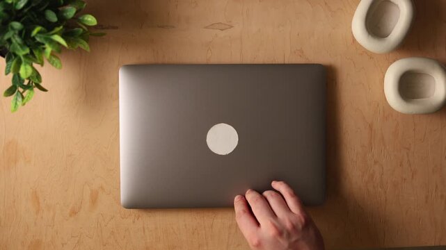 Top view of a laptop and headphones on a wooden desk