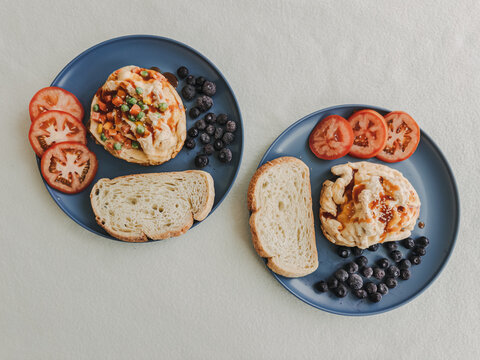 Delicious savory pastries with mixed vegetables, fresh tomatoes, blueberries, and bread slices