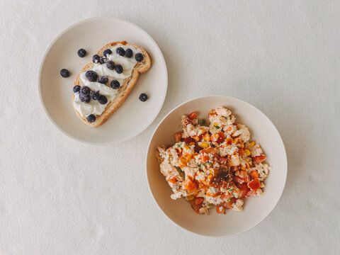 Healthy and Nutritious Breakfast Spread Featuring Scrambled Eggs with Vegetables and Blueberry Toast