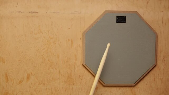 Drum practice pad with sticks for quiet rhythmic training and skill development
