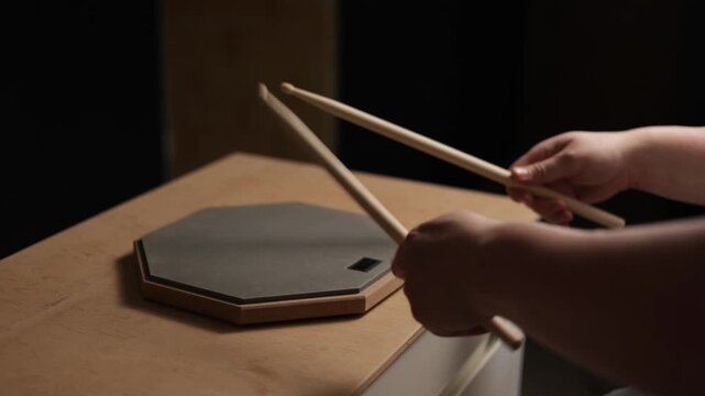 Close-up of hands practicing drum rudiments on a practice pad