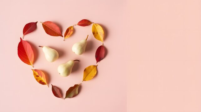 A heart shape made of colorful autumn leaves on a soft pastel pink background with copy space