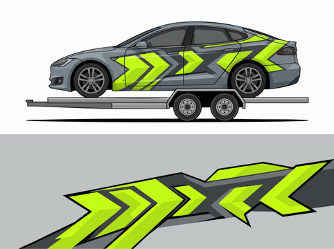 Gray car with neon green geometric wrap on flatbed trailer