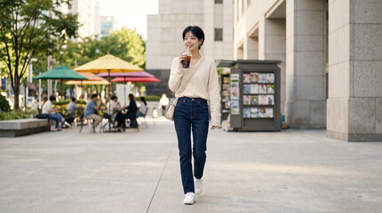 Naklejka premium 도심 거리를 걷는 캐주얼 룩 여성 Woman in Casual Look Walking on a City Street
