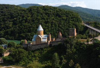 Fototapeta premium Ananuri Fortress surrounded by green mountains and forests in Georgia