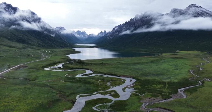 	
Beautiful green grassland and lake under cloudy sky 
