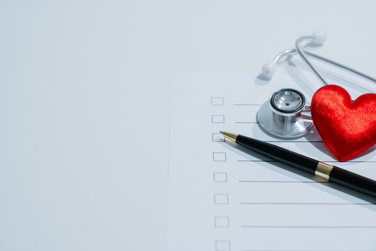 Medical checklist concept. Stethoscope, red heart and pen on health assessment form for checkup, screening, prevention, diagnosis, care