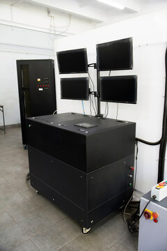 Robust black modular bench hosts integrated control and monitoring; quad-screen array and emergency panel support real-time diagnostics. Industrial setup emphasizes precision testing in technical envi