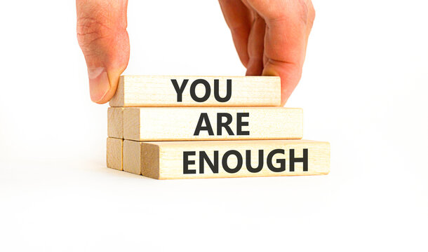 You are enough words symbol. Concept words You are enough on beautiful wooden blocks. Beautiful white background. Businessman hand. Business motivational and you are enough concept. Copy space.