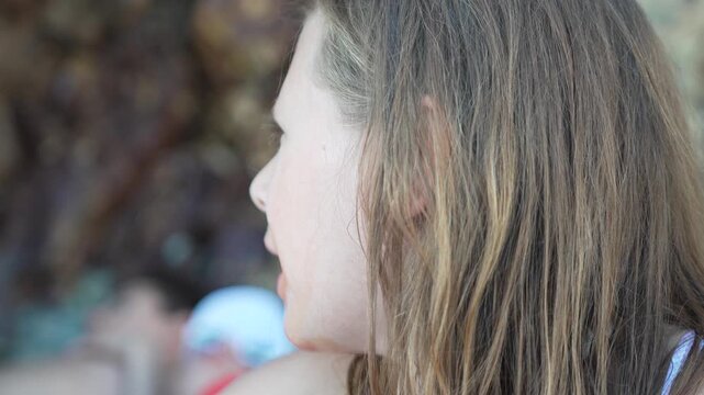 Young girl with birthmark on her face looking around outdoors, medium close up shot.