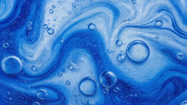 Close-up of clear liquid bubbles on a swirling blue textured surface