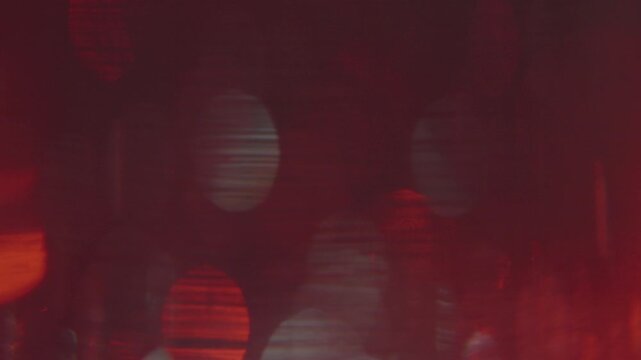 A video background featuring a shimmering deep red effect, conveying a sense of mystery and sophisticated luxury.