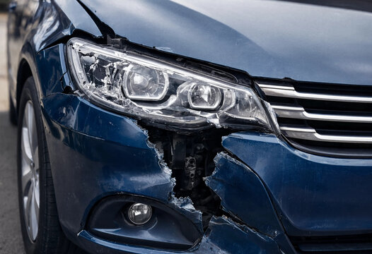 Broken Blue Car Headlight and Front Bumper Damage After Auto Accident
