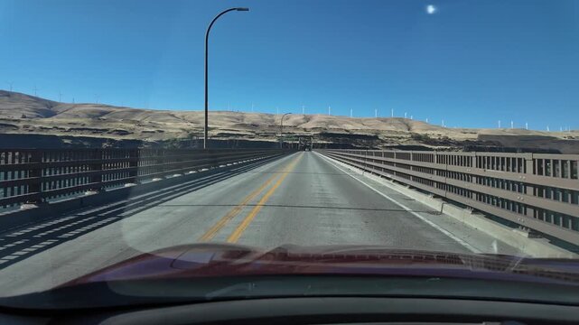 4K driving footage crossing the Sam Hill Memorial Bridge over the Columbia River in Oregon, USA. Driver's point of view traveling between Oregon and Washington with wind turbines visible on hills