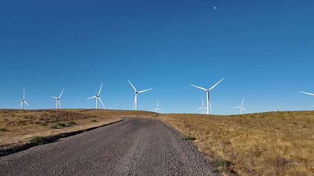 4K pocket action camera footage of a wind farm near Arlington, Columbia River Gorge, Oregon, USA at morning light. Rotating wind turbines producing clean renewable electricity in strong winds