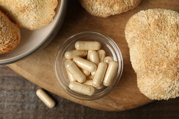 Functional mushrooms and pills on wooden table, top view © New Africa