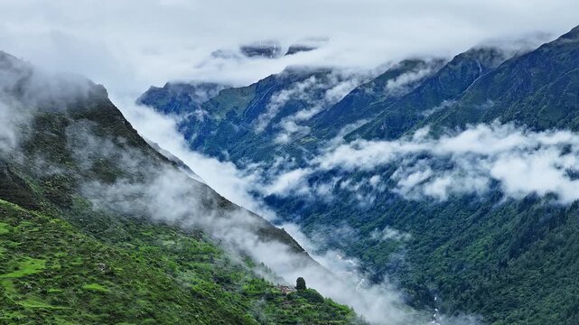 Aerial view of the summer landscape in Shuangqiao Valley Scenic Area of Mount Siguniang, Aba Prefecture, Sichuan, China, with mist-shrouded mountains