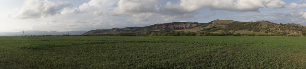 Fototapeta premium Panoramic view of Rapa Rosie (Red Ravine) natural monument and green agricultural fields in Romania