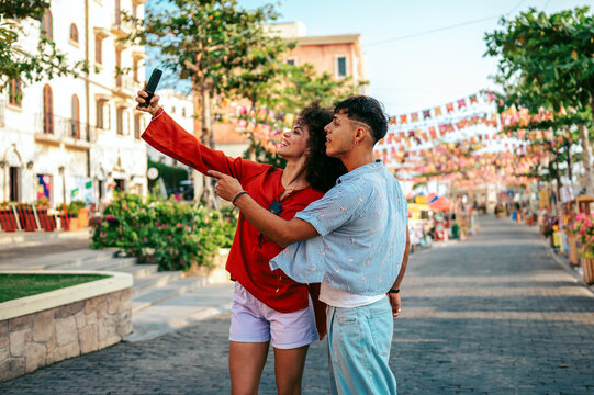 Young people capturing the vibrant urban tropical vibe, happily taking a selfie on a colorful street