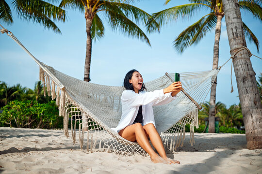 Content creator woman taking a selfie or streaming live from a scenic beach