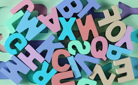 Colorful wooden alphabet letters background and texture, top view, design element