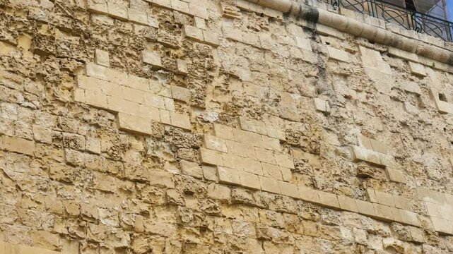 weathered limestone masonry blocks form a valletta bastion wall close texture detail irregular stone pattern valletta fortification limestone bastion wall knights of malta walls 16th century fortress