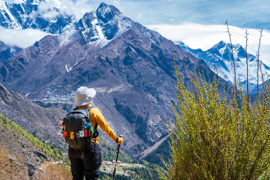 Mujer senderista caminando por los espectaculares caminos del valle khumbu. Yendo al Everest Base Camp, en Nepal.