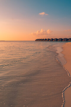Maldives travel minimal landscape. Serene golden sunset calm sea wooden pier tropical shore glowing evening sky. Perfect summer travel paradise. Warm romantic coastal getaway scenic backdrop art