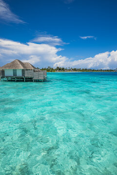 Luxury Maldives overwater villa turquoise lagoon tropical island paradise resort clear ocean water. Perfect summer vacation travel landscape. Exotic stunning honeymoon getaway relax scenic backdrop