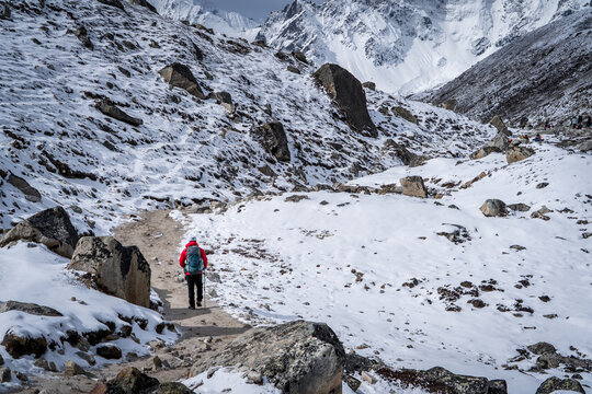 Senderista con campera roja en su camino al campamento base del Everest, en Nepal	