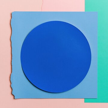 Cobalt blue halftone circle on layered torn teal and pink paper sheets with tactile ink textures for graphic design and poster mockups