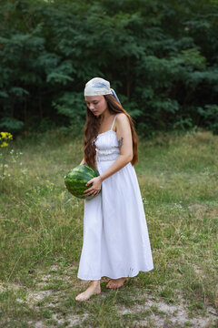 Cottagecore style girl with fresh watermelon walking in nature