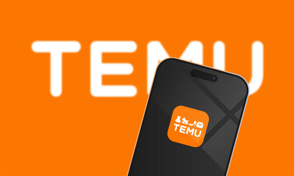 Smartphone displaying Temu shopping app logo on screen against orange background