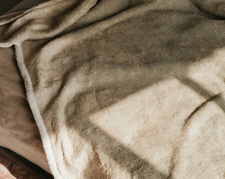 Woven pet blanket texture with a worn sage green and khaki pile, featuring soft pilling and snagged threads for homeware and textile backgrounds
