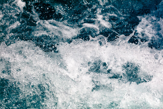 Churning ocean waves crash with white foam