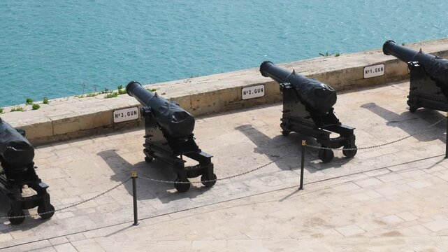 numbered saluting cannons stand in a row gun markers labeling each piece valletta historic artillery detail saluting battery cannon valletta artillery historic cannon detail malta gun battery