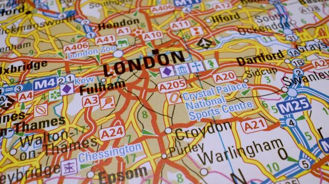 Camera panning close up on a map focusing on motorways heading into London