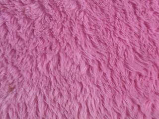 Detailed close up background texture of soft pink fake fur fabric. High quality cozy plush material perfect for fashion design, textile background, carpet, or warm winter design ideas © Eka
