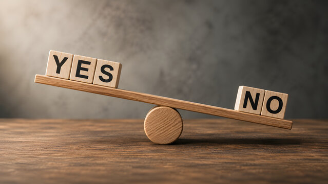 Wooden blocks spelling yes and no balancing on a seesaw scale. Concept of business decision making and risk assessment choice.
