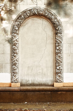 ornate stone archway framed by carved reliefs cracked plaster, evoking historic architecture, texture, age and timeless elegance for backgrounds, restoration projects and interior design inspiration