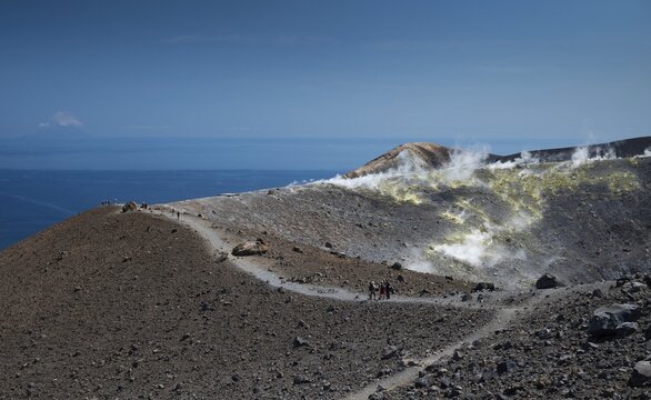 Visitors walk along the crater rim, sulfur vapors rise, in the background the Mediterranean Sea, Vulcano, Aeolian or Aeolian Islands, Sicily, Southern Italy, Italy