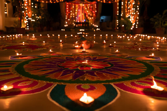 A spectacular sight during Diwali, featuring vibrant rangoli and elegant traditional lamps set against a beautifully decorated backdrop at night