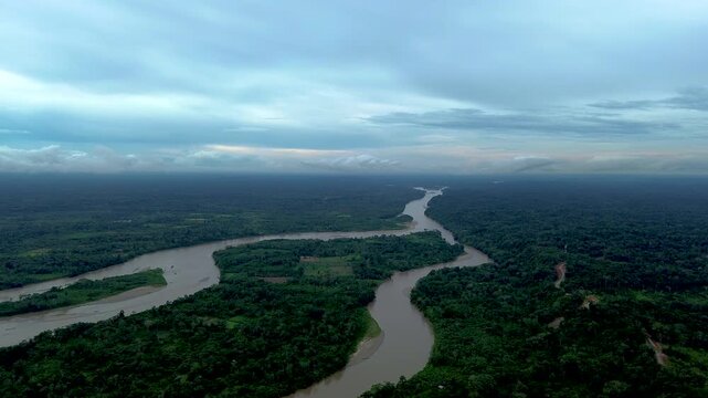 Drone View of Meandering Amazon River Through Dense Ecuador Rainforest, Brown Water, Forest Islands, Cloudy Sky and Remote Tropical Wilderness Landscape