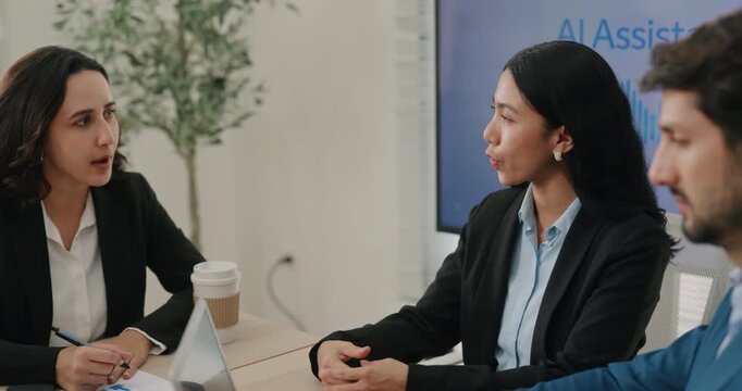 Portrait of Asian lady manager discusses AI assistant with partners in boardroom. Multiracial marketing team plans chat bots usage in customer service in office