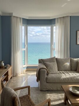 Spacious living room with sofa and bay window overlooking turquoise sea