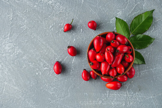 fresh red rose hips on a stone background